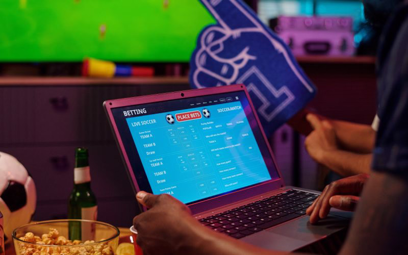 A strategic young fan in an Argentina national jersey, analyzing live data on his smartphone featuring the GanaEnCasa in-play betting interface.